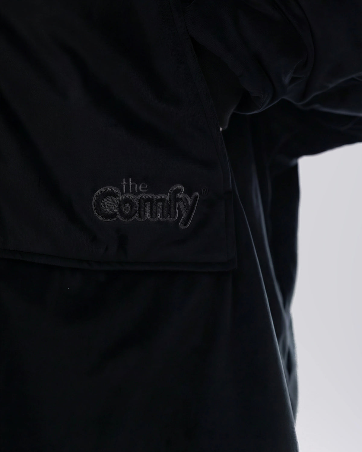 Close-up of The Original Full-Zip in Black showing its fabric and embroidered logo.
