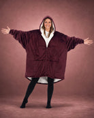 Person wearing The Original Full-Zip wearable blanket in Burgundy with arms outstretched, showcasing oversized fit and full-length zipper.