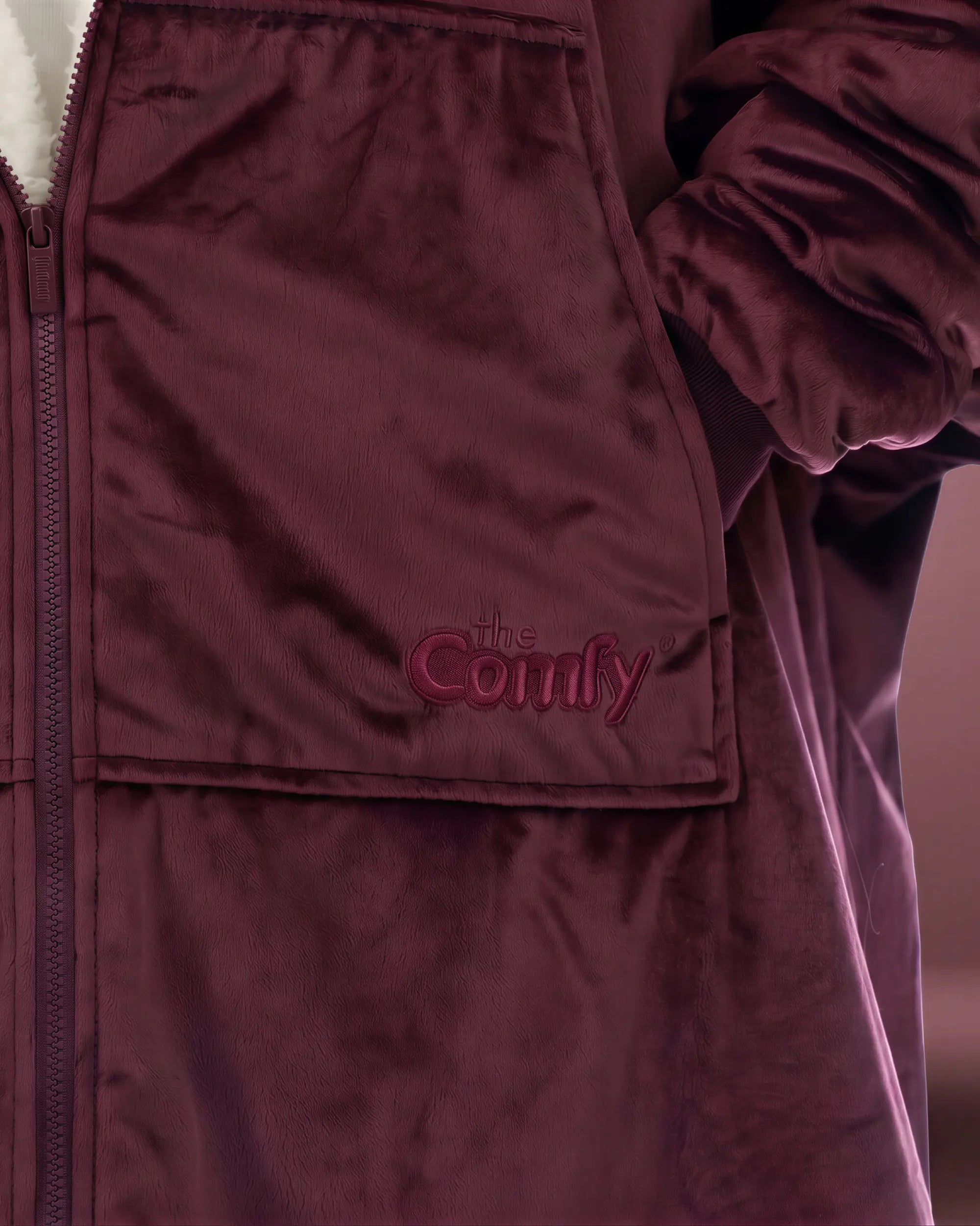Close-up of The Original Full-Zip Burgundy wearable blanket featuring embroidered The Comfy logo and Velveluxe™ fabric.