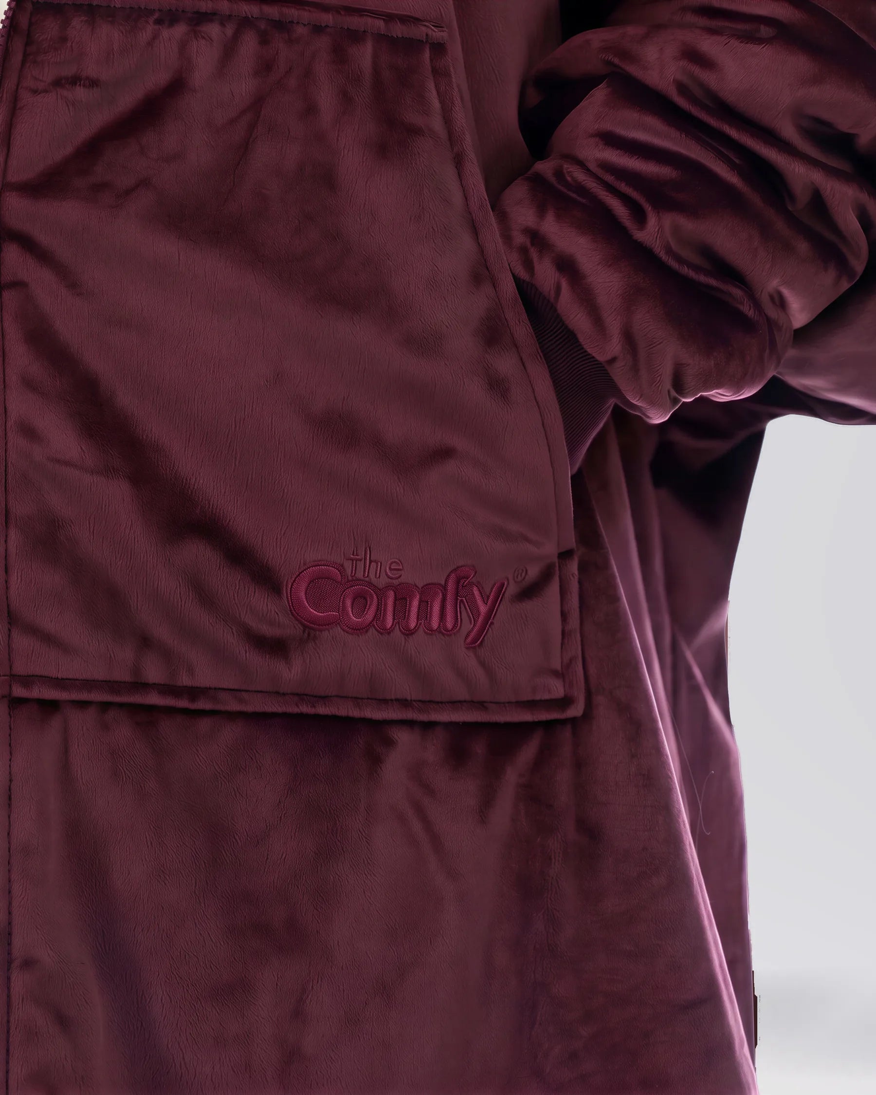 Close-up of The Original Full-Zip Burgundy wearable blanket featuring embroidered The Comfy logo and Velveluxe™ fabric.
