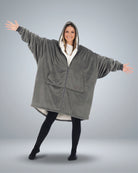 Front view of The Original Full-Zip wearable blanket in charcoal with arms extended showing oversized fit and zipper closure