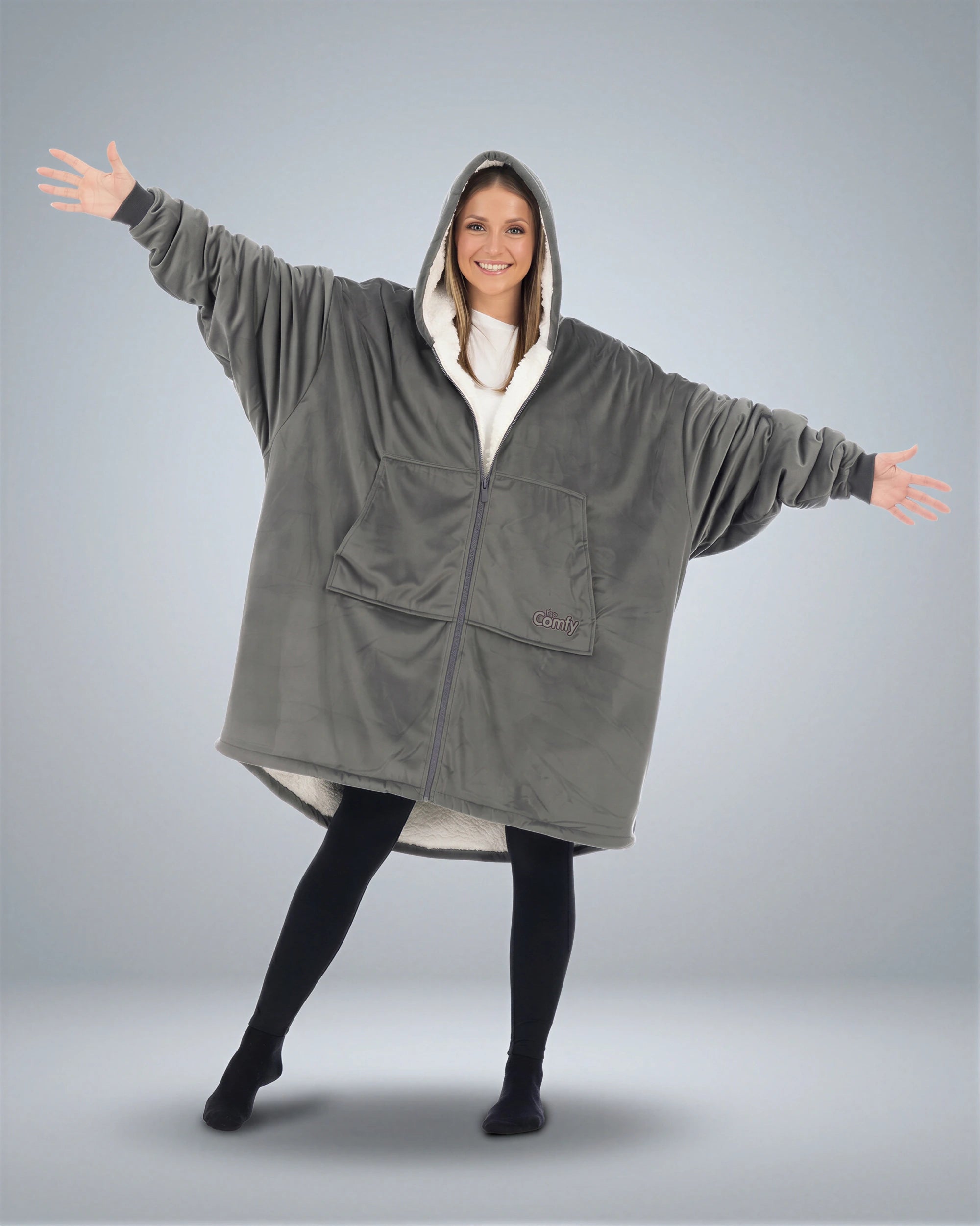 Front view of The Original Full-Zip wearable blanket in charcoal with arms extended showing oversized fit and zipper closure