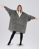 Front view of The Original Full-Zip wearable blanket in charcoal with arms extended showing oversized fit and zipper closure