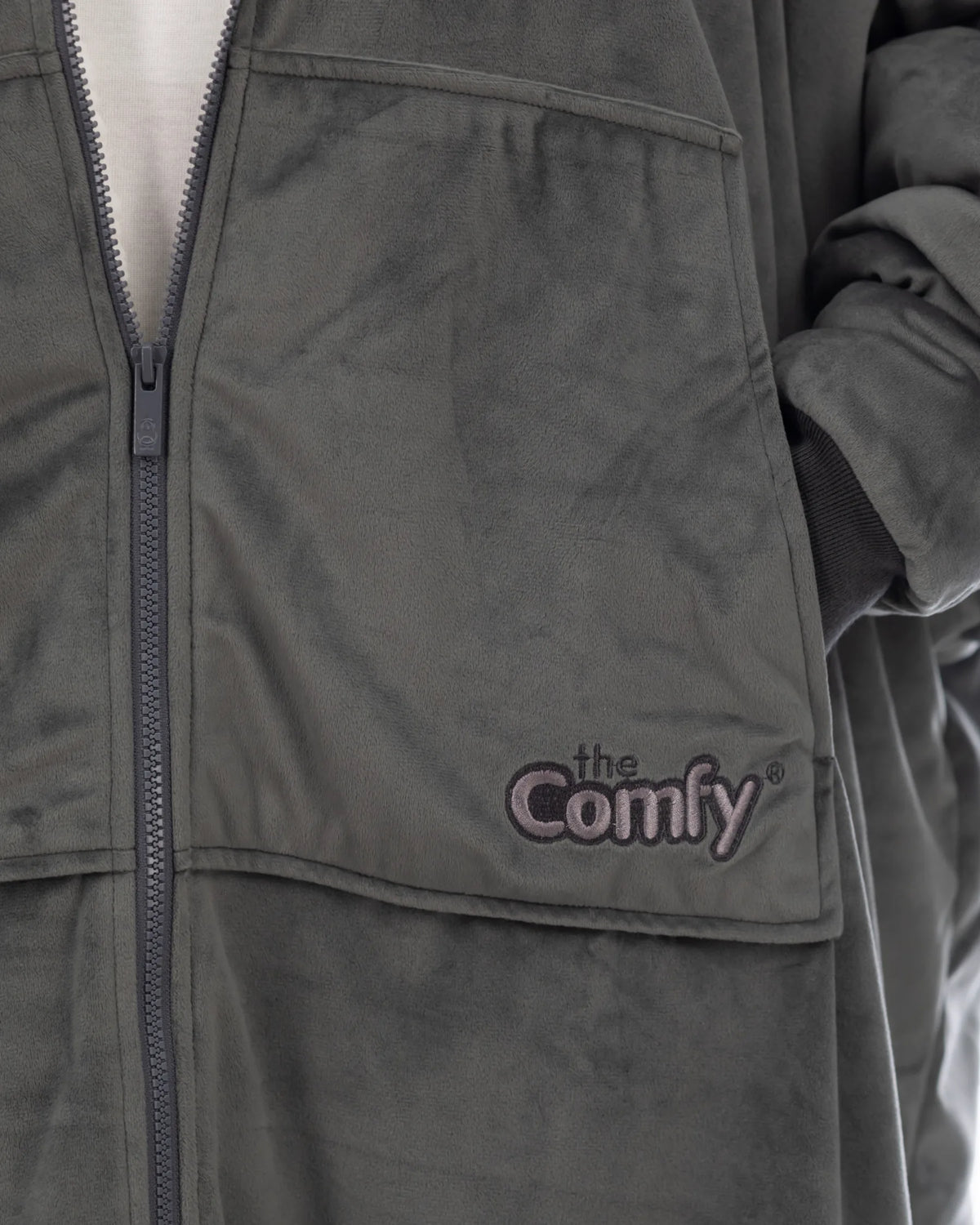 Close-up of The Original Full-Zip wearable blanket in charcoal showing zipper detail, Velveluxe™ exterior, and embroidered logo