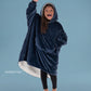 Child wearing The Original Jr. wearable blanket in Blue with CloudSherpa™ lining, waving and showing the oversized fit designed for cozy comfort.