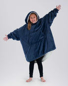 Child wearing The Original Jr. Blue wearable blanket with arms outstretched, highlighting the roomy design and oversized coverage.