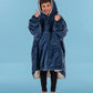 Child wearing The Original Jr. Blue wearable blanket with hood up and thumbs raised, showcasing all-day comfort and a cozy fit.
