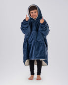 Child wearing The Original Jr. Blue wearable blanket with hood up and thumbs raised, showcasing all-day comfort and a cozy fit.