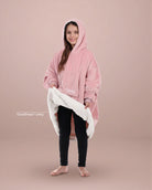 Child wearing The Original Jr. wearable blanket in Blush, holding open the hem to reveal the CloudSherpa™ lining.
