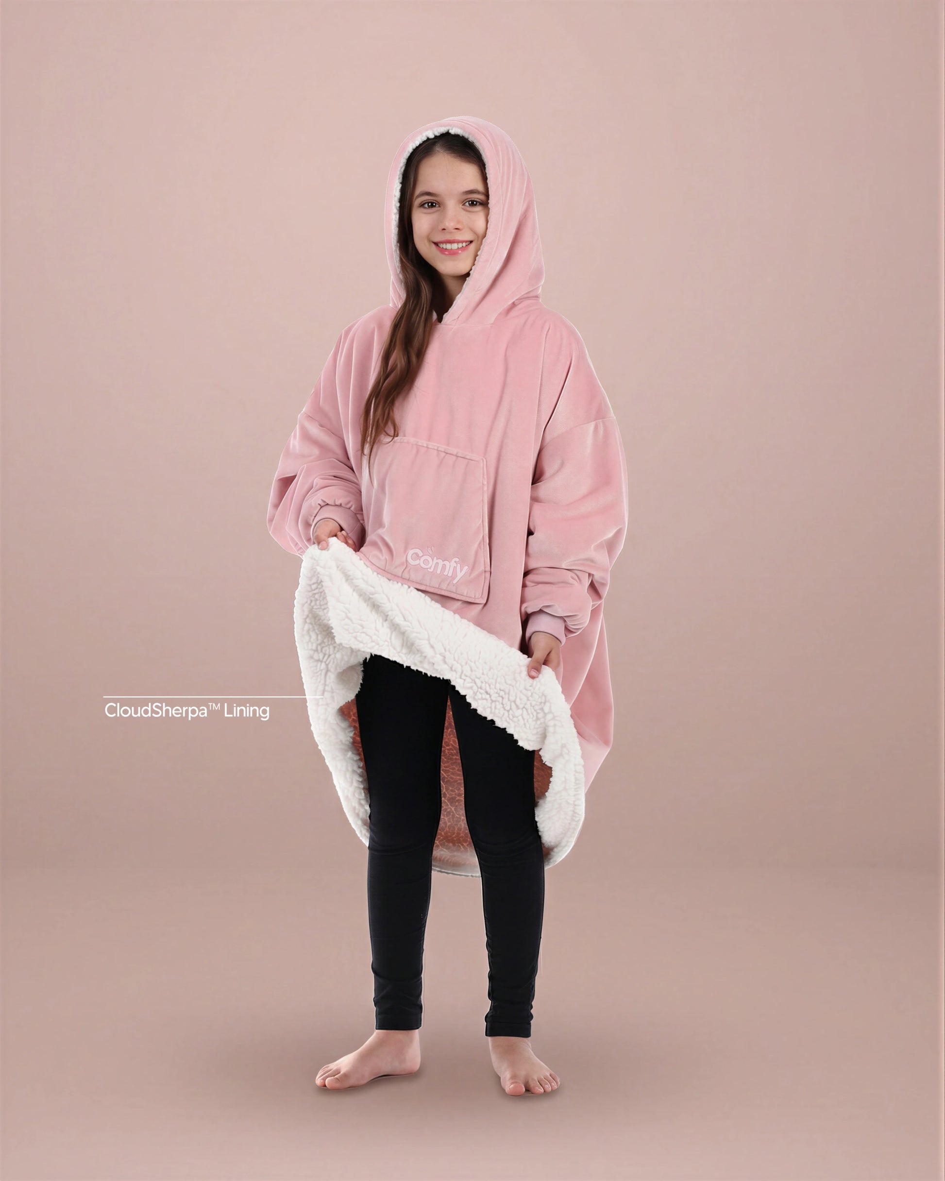 Child wearing The Original Jr. wearable blanket in Blush, holding open the hem to reveal the CloudSherpa™ lining.