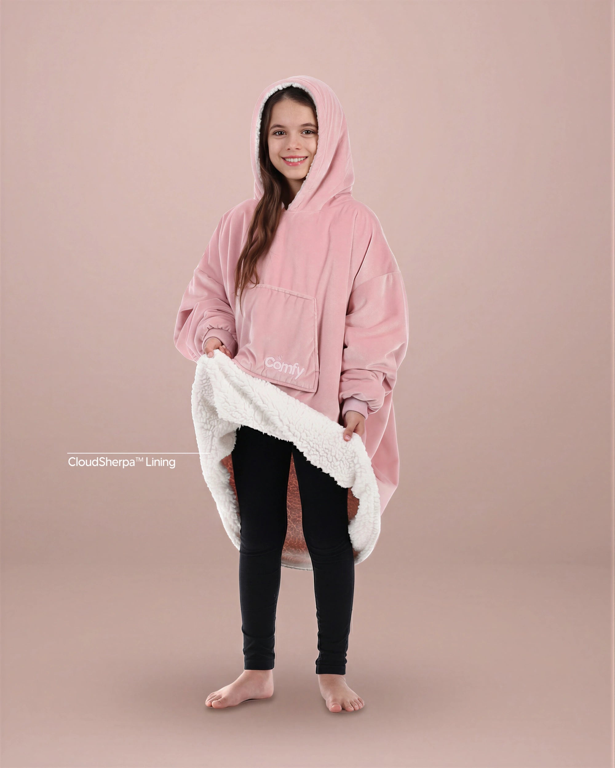 Child wearing The Original Jr. wearable blanket in Blush, holding open the hem to reveal the CloudSherpa™ lining.