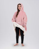 Child wearing The Original Jr. wearable blanket in Blush, holding open the hem to reveal the CloudSherpa™ lining.