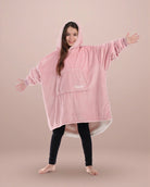 Child wearing The Original Jr. Blush wearable blanket with arms outstretched, showcasing roomy coverage and cozy comfort.