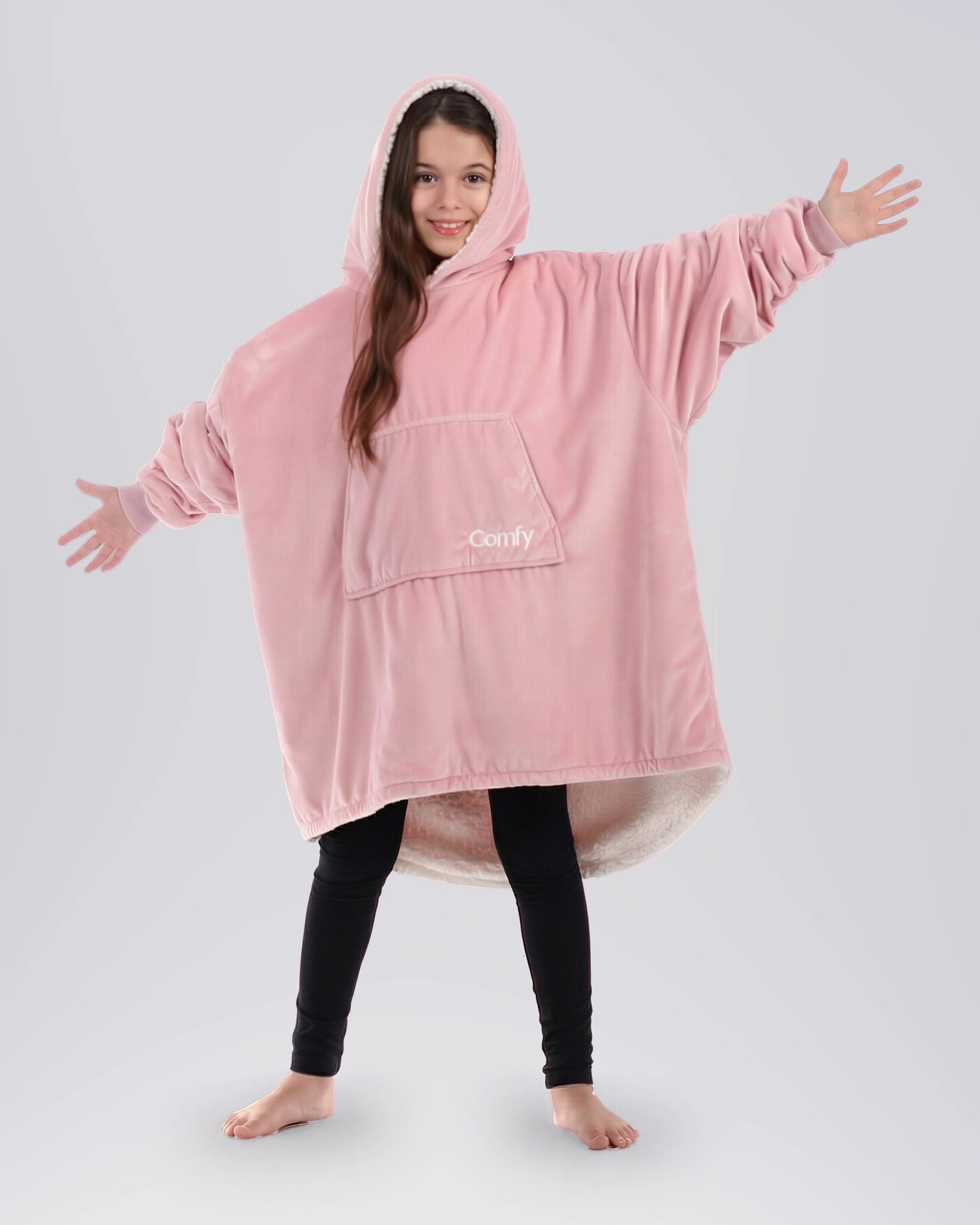 Child wearing The Original Jr. Blush wearable blanket with arms outstretched, showcasing roomy coverage and cozy comfort.
