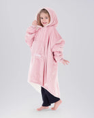 Child wearing The Original Jr. Blush wearable blanket with hood up, featuring the oversized silhouette and front kangaroo pocket.