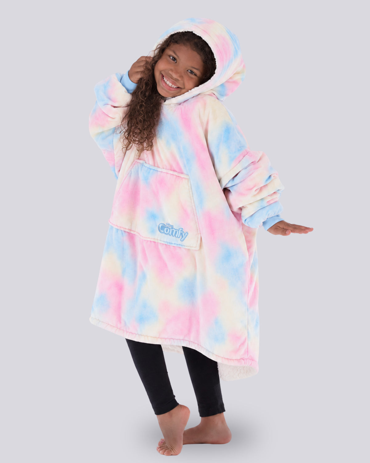 Child wearing The Original Jr. Cotton Candy Tie Dye wearable blanket in a playful pose, highlighting the oversized hood, kangaroo pocket, and cozy comfort.