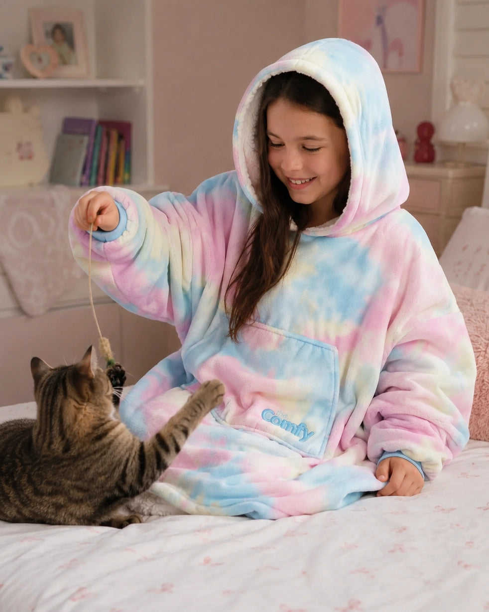 A child in a Cotton Candy Original Jr. wearable blanket plays with a cat.