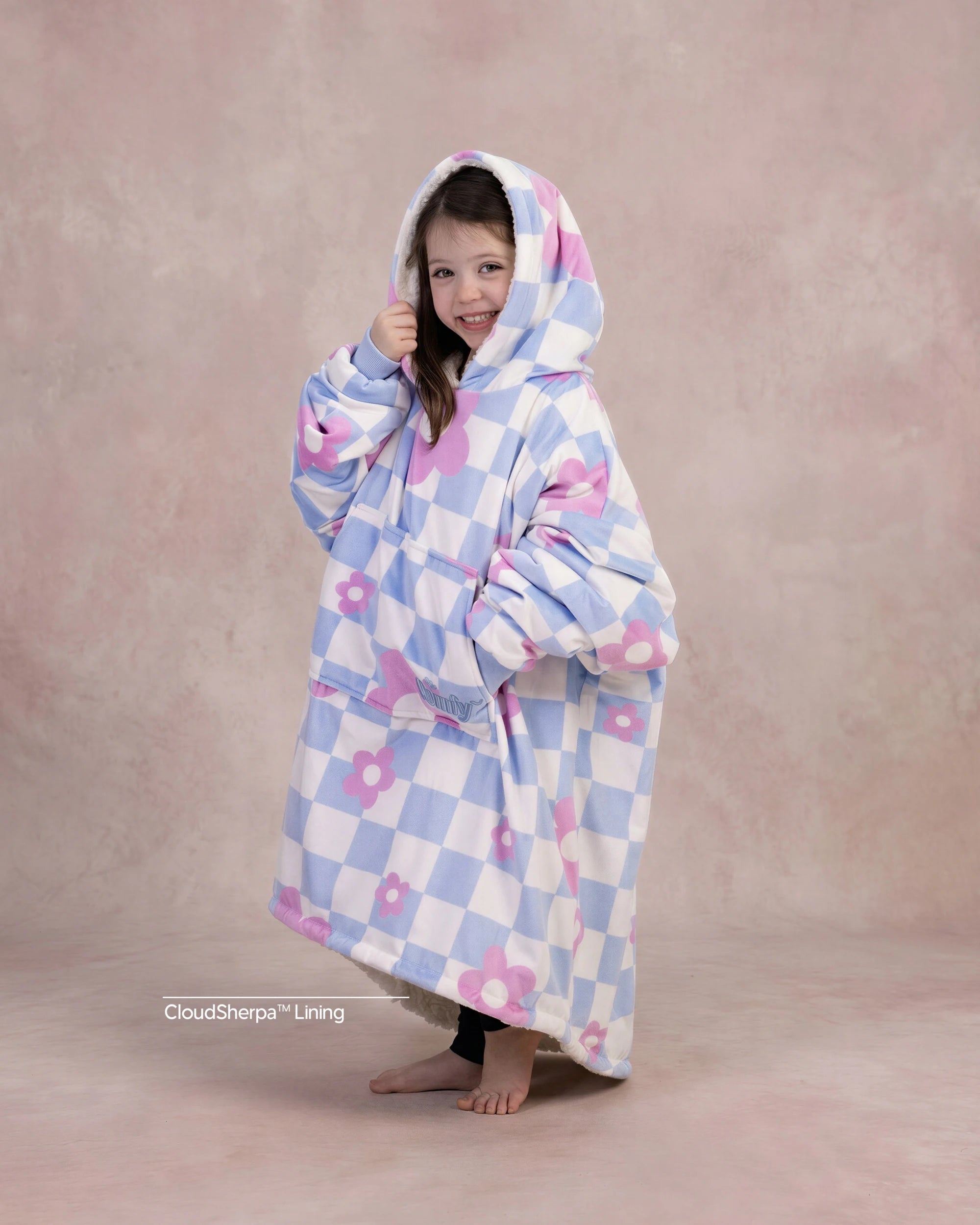 Child wearing The Original Jr. Flower Checkered wearable blanket with CloudSherpa™ lining, showcasing the playful checkered floral pattern and oversized fit.