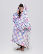 Child wearing The Original Jr. Flower Checkered wearable blanket with CloudSherpa™ lining, showcasing the playful checkered floral pattern and oversized fit.