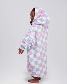 Side and back view of a child wearing The Original Jr. Flower Checkered wearable blanket, showcasing the oversized silhouette and hood design.