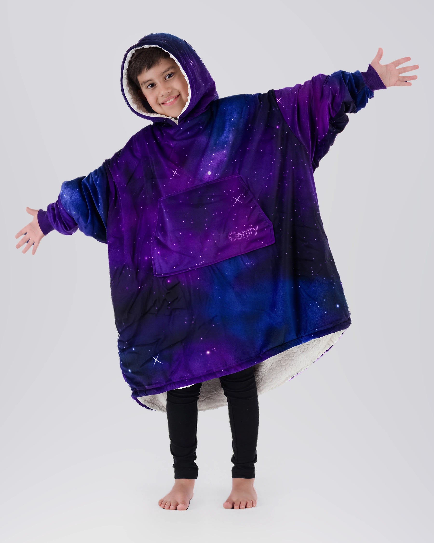 Child wearing The Original Jr. Galaxy wearable blanket with arms outstretched, showcasing the oversized fit, celestial-inspired print, and CloudSherpa™ lining.
