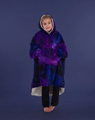 Child standing comfortably in The Original Jr. Galaxy wearable blanket, featuring full-body warmth and the roomy oversized silhouette.