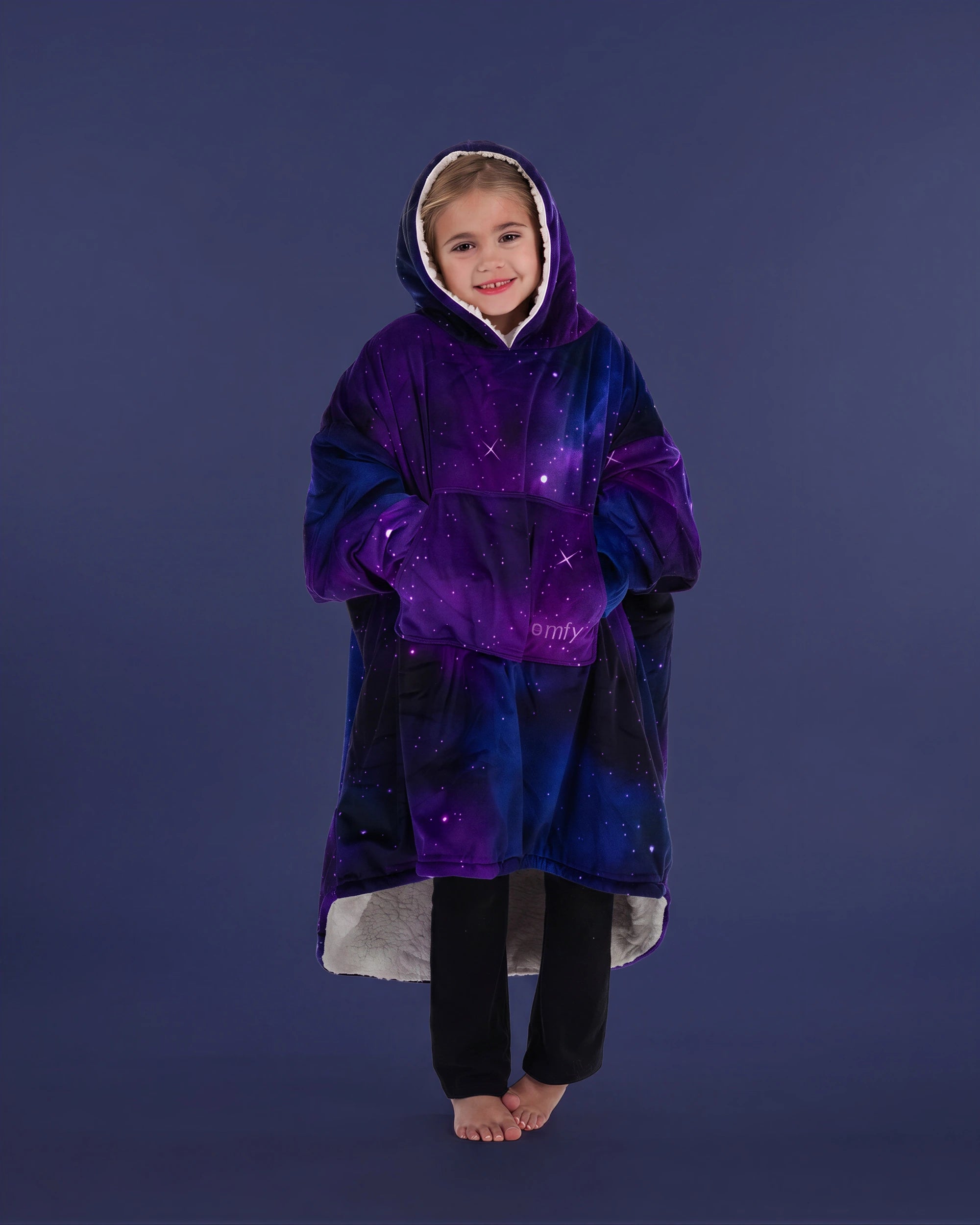 Child standing comfortably in The Original Jr. Galaxy wearable blanket, featuring full-body warmth and the roomy oversized silhouette.
