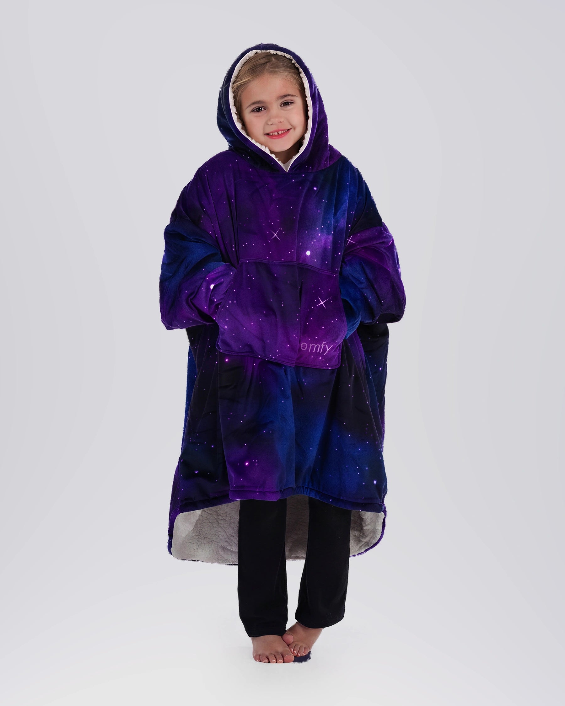 Child standing comfortably in The Original Jr. Galaxy wearable blanket, featuring full-body warmth and the roomy oversized silhouette.