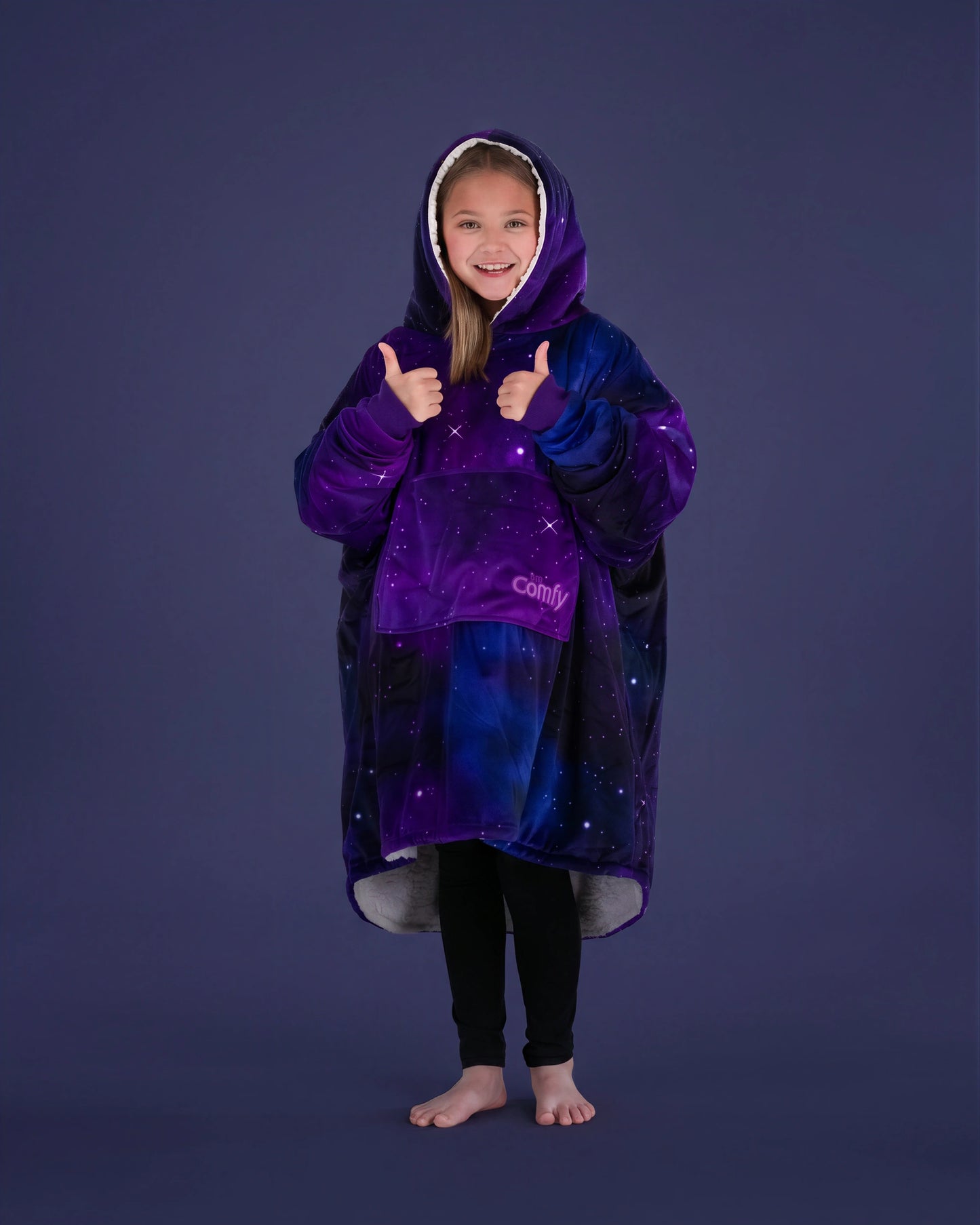Child giving a thumbs up while wearing The Original Jr. Galaxy wearable blanket, showcasing all-day comfort and cozy coverage.