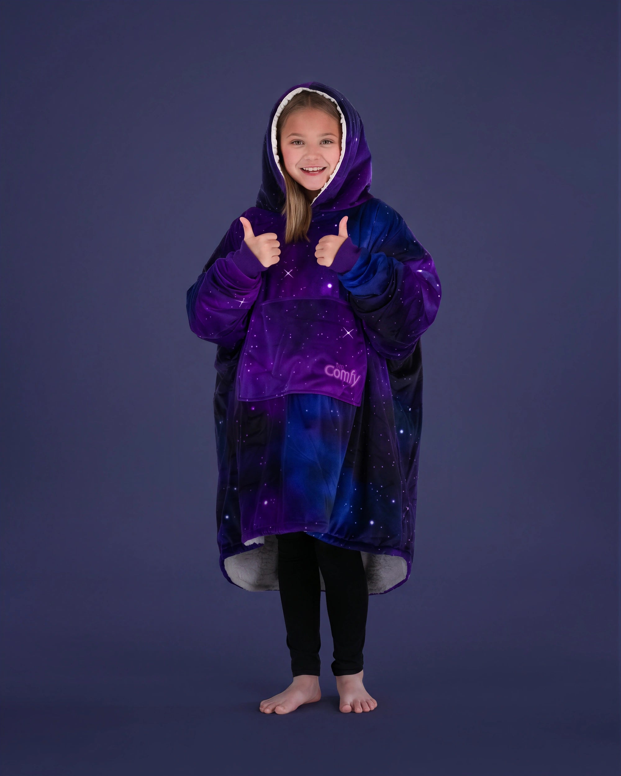 Child giving a thumbs up while wearing The Original Jr. Galaxy wearable blanket, showcasing all-day comfort and cozy coverage.