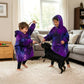 Two children playing indoors with a dog while wearing The Original Jr. Galaxy wearable blankets, designed for comfort during playtime, movie nights, and relaxing at home.