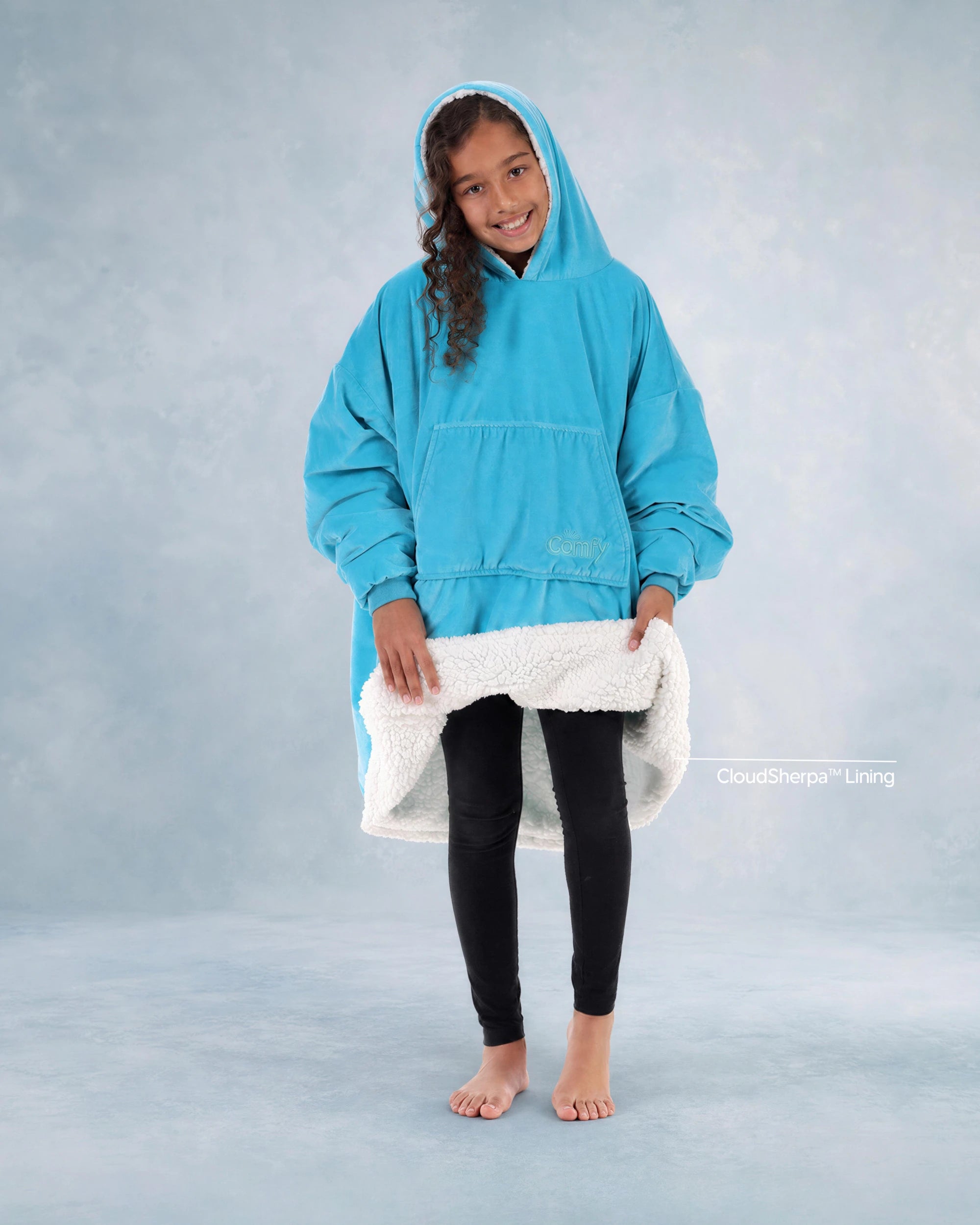Child wearing The Original Jr. Neon Aqua wearable blanket while showing the CloudSherpa™ lining, highlighting the oversized fit and ultra-cozy construction.