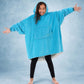 Rear view of a child wearing The Original Jr. Neon Aqua wearable blanket, highlighting the oversized hood and generous coverage.