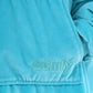 Close-up of The Original Jr. Neon Aqua wearable blanket, featuring the ultra-soft fabric texture and embroidered logo detail.