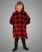 Child standing in The Original Jr. Red Plaid wearable blanket, highlighting the oversized fit, roomy kangaroo pocket, and full-body warmth.