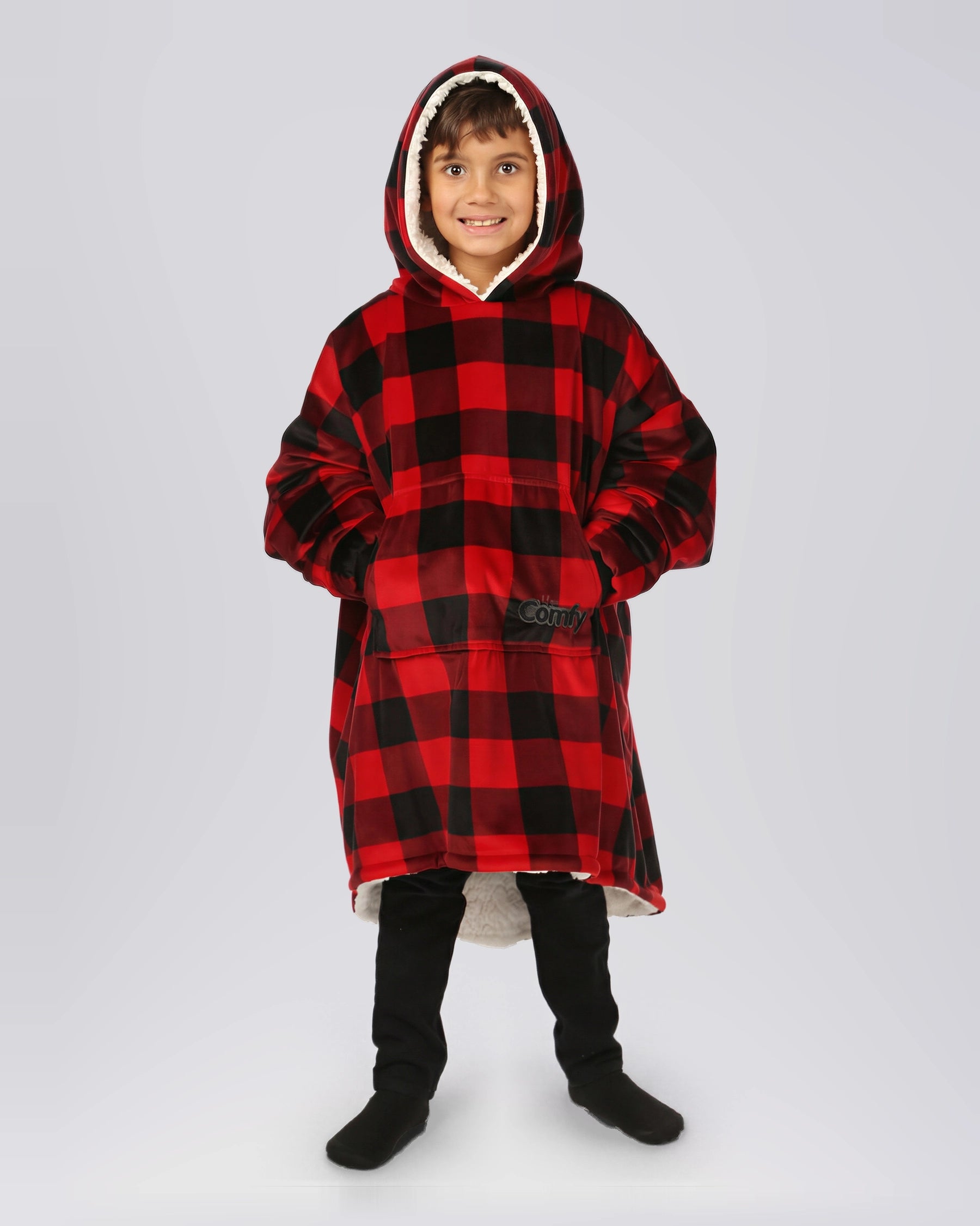 Child standing in The Original Jr. Red Plaid wearable blanket, highlighting the oversized fit, roomy kangaroo pocket, and full-body warmth.
