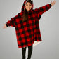 Child wearing The Original Jr. Red Plaid wearable blanket with arms outstretched, demonstrating the roomy oversized design and unrestricted comfort for relaxing or play.