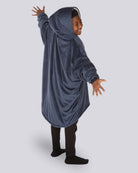 Child wearing The Original Jr. wearable blanket in Blue showing the back with arms stretch out to show the oversized fit and hood.