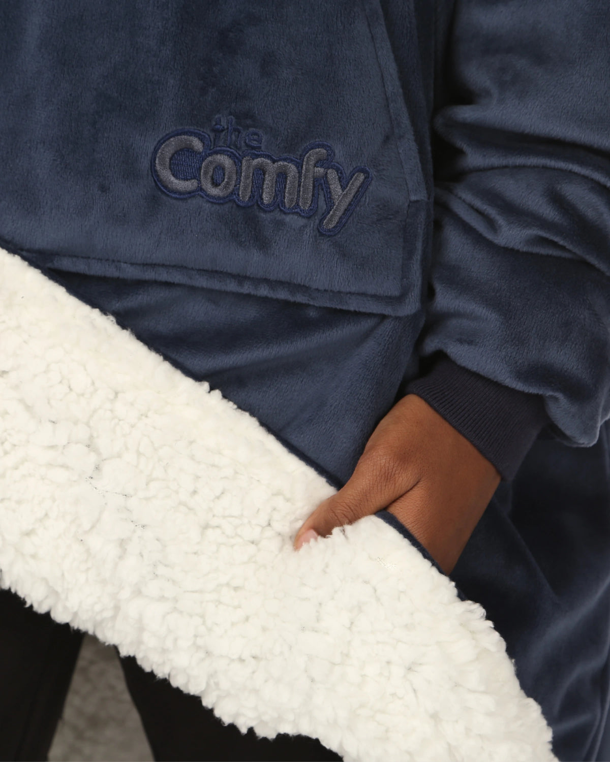 Close up of the sherpa lining and oversized pocket of The Original Jr. wearable blanket in Blue.