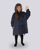 Child wearing The Original Jr. wearable blanket in Blue with CloudSherpa™ lining, waving and showing the oversized fit designed for cozy comfort.