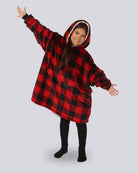 Child wearing The Original Jr. Red Plaid wearable blanket with arms outstretched, demonstrating the roomy oversized design and unrestricted comfort for relaxing or play.
