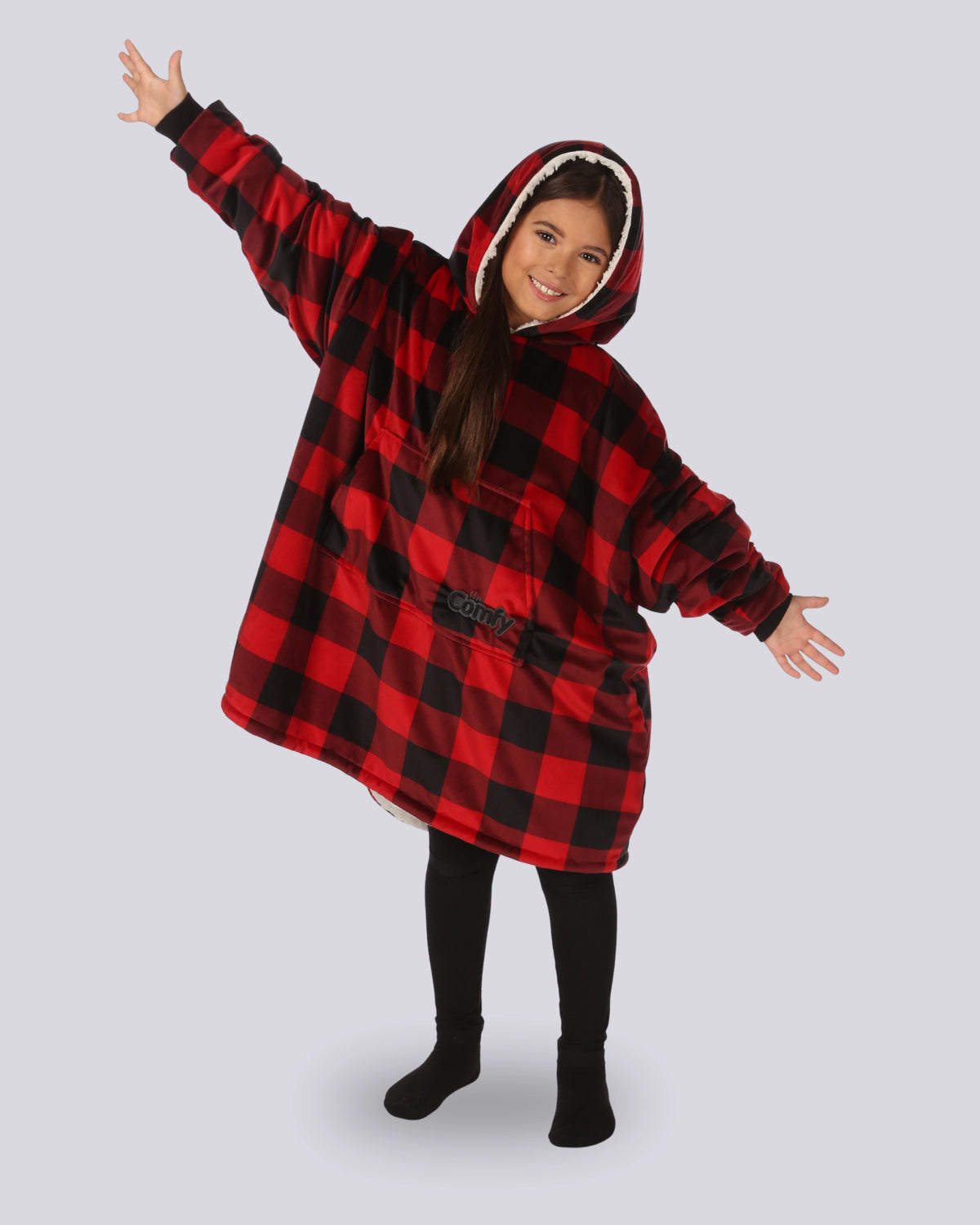 Child wearing The Original Jr. Red Plaid wearable blanket with arms outstretched, demonstrating the roomy oversized design and unrestricted comfort for relaxing or play.