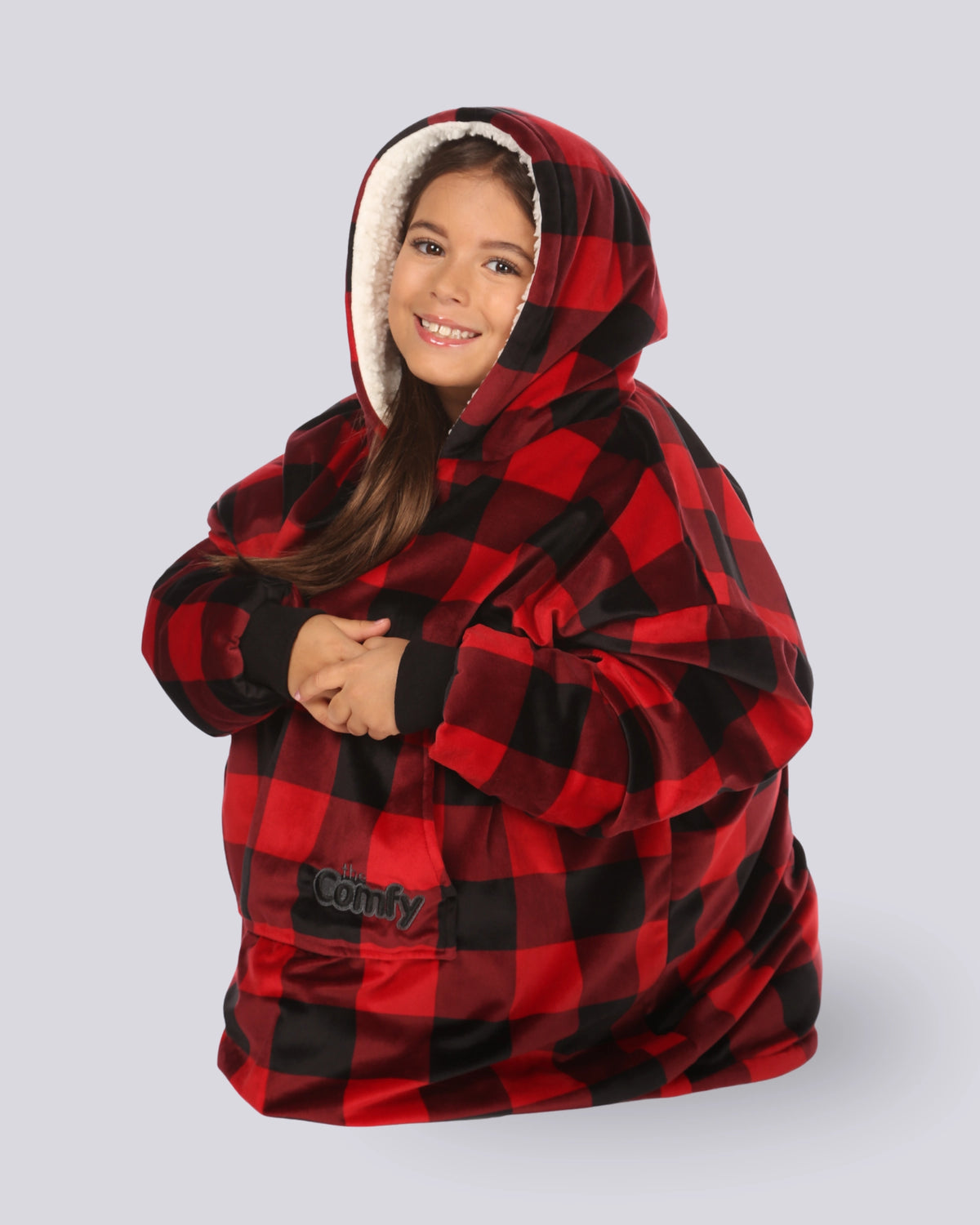 Child wearing The Original Jr. Red Plaid wearable blanket curled up with legs tucked under.