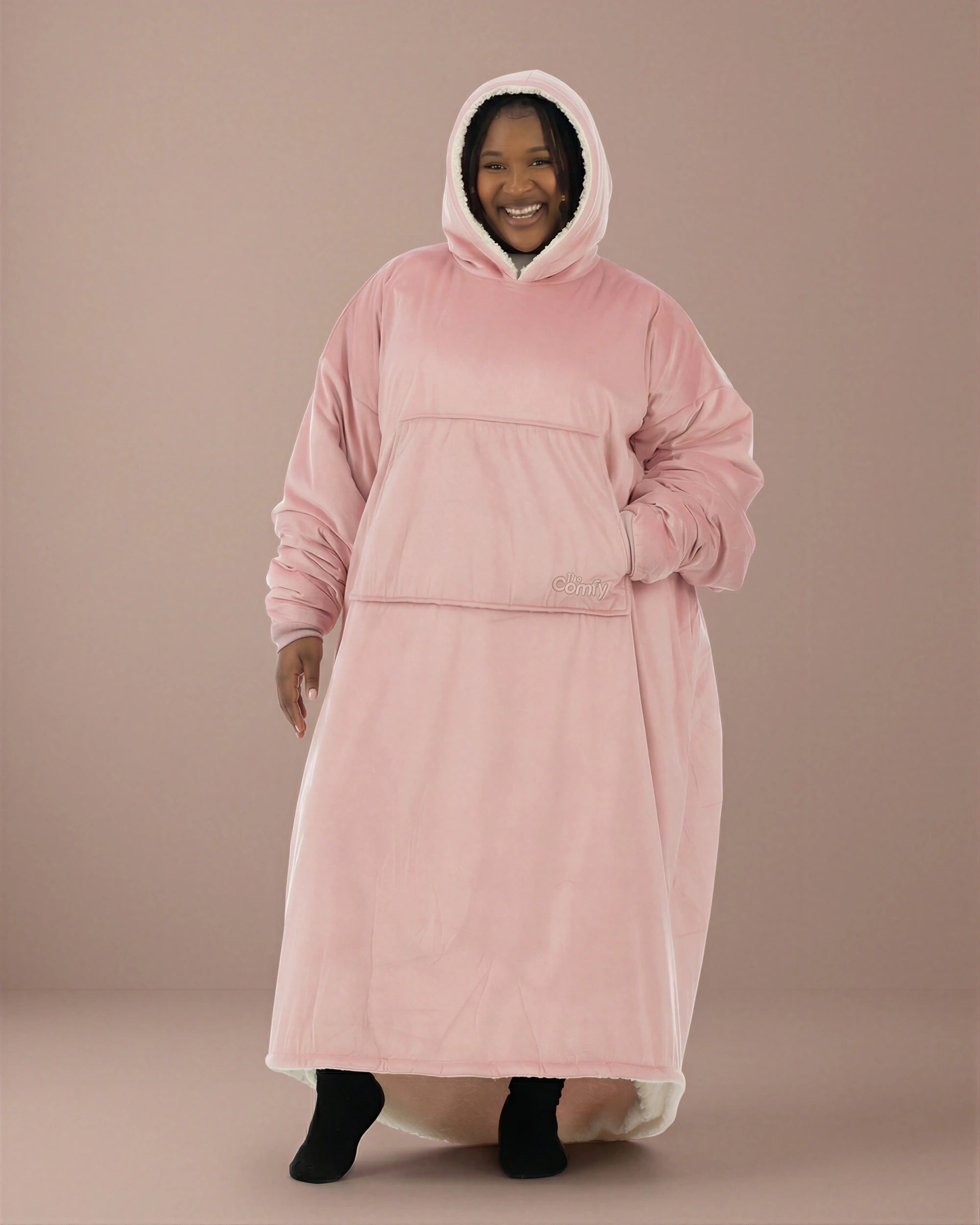 Woman wearing The Comfy Original Long in blush, casual front view with hood up and hand in kangaroo pocket.