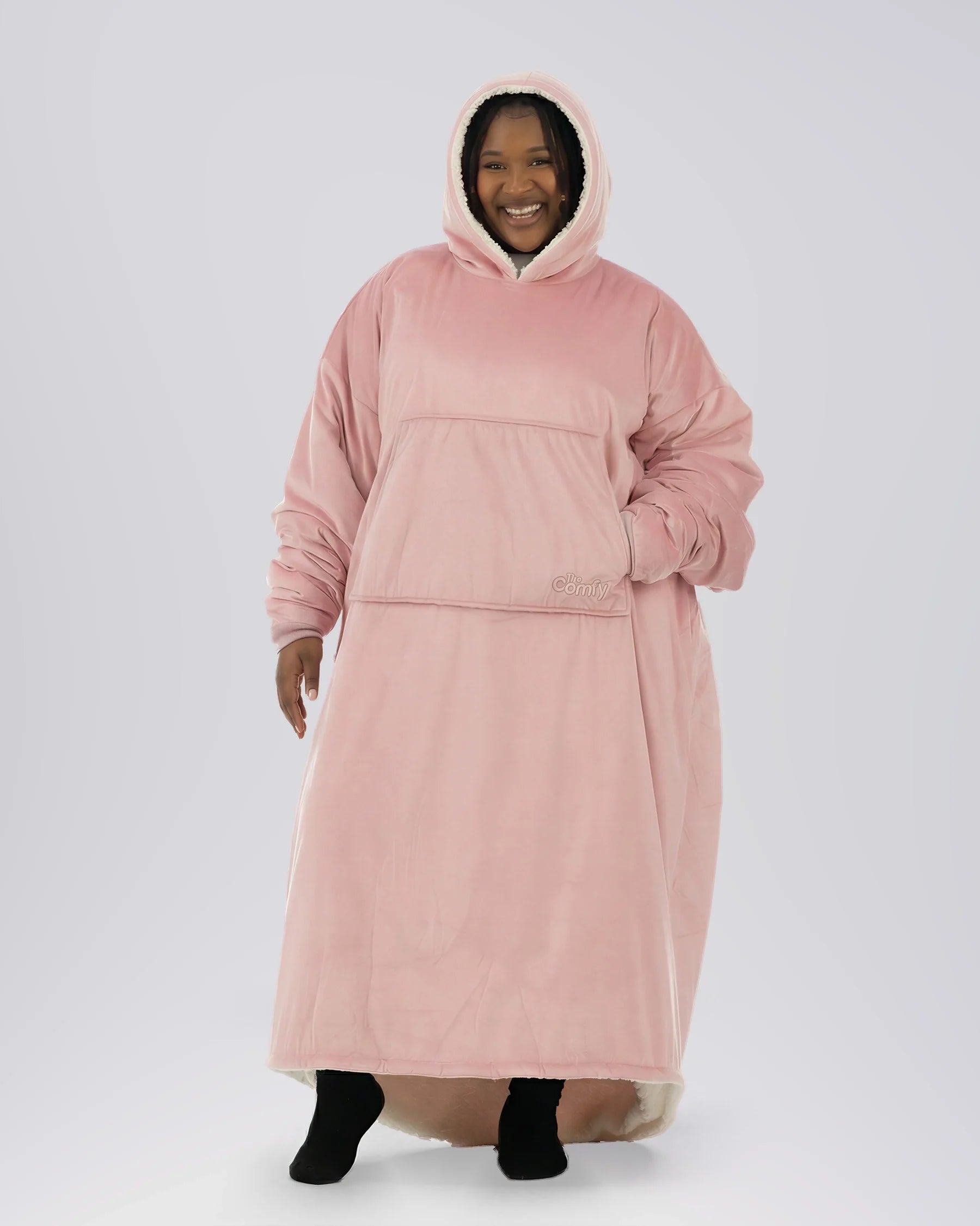 Woman wearing The Comfy Original Long in blush, casual front view with hood up and hand in kangaroo pocket.