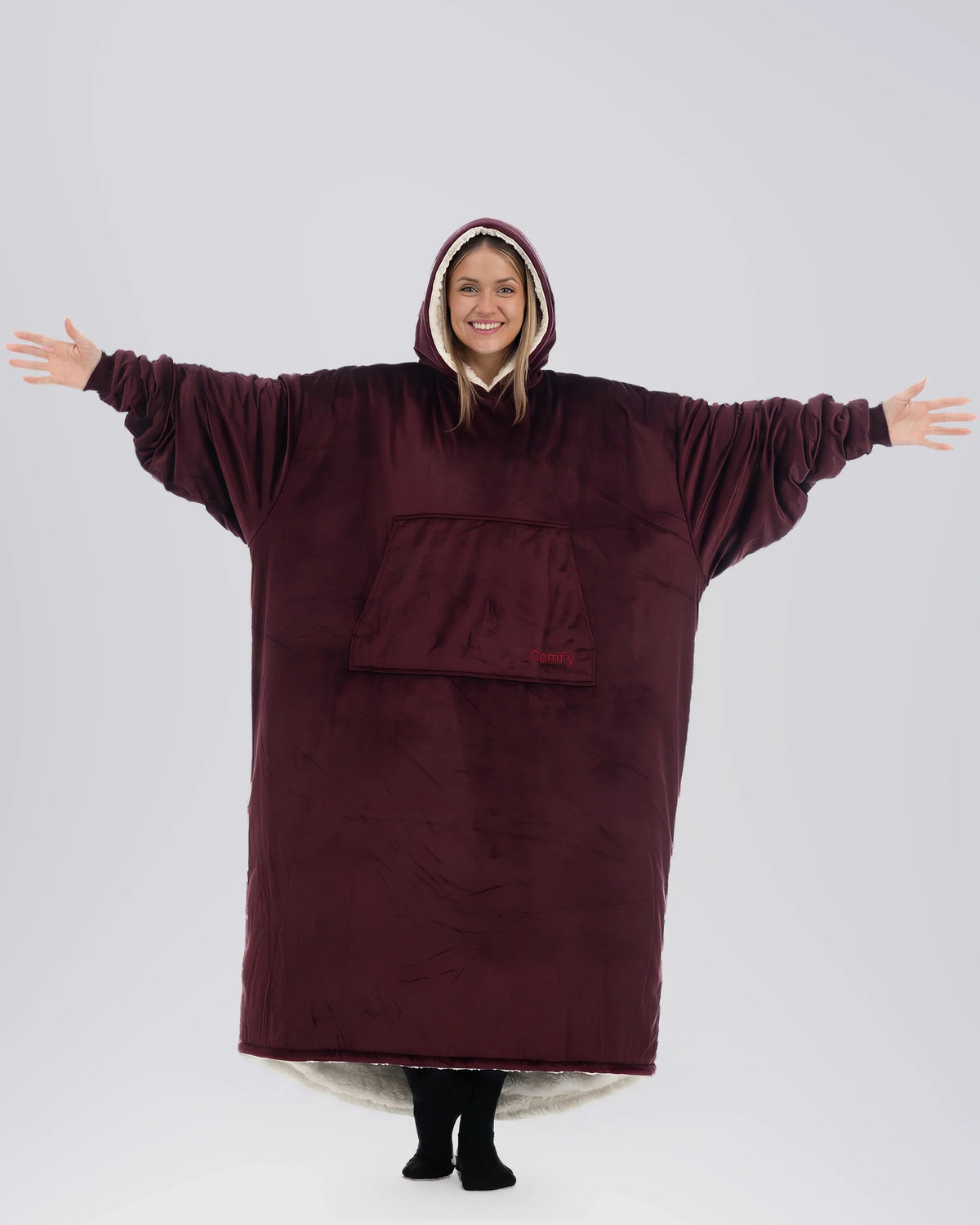 Woman wearing The Comfy Original Long in burgundy with CloudSherpa™ lining, arms extended to show oversized fit.