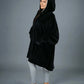 Side view of The Original wearable blanket in black showing oversized fit and hood design