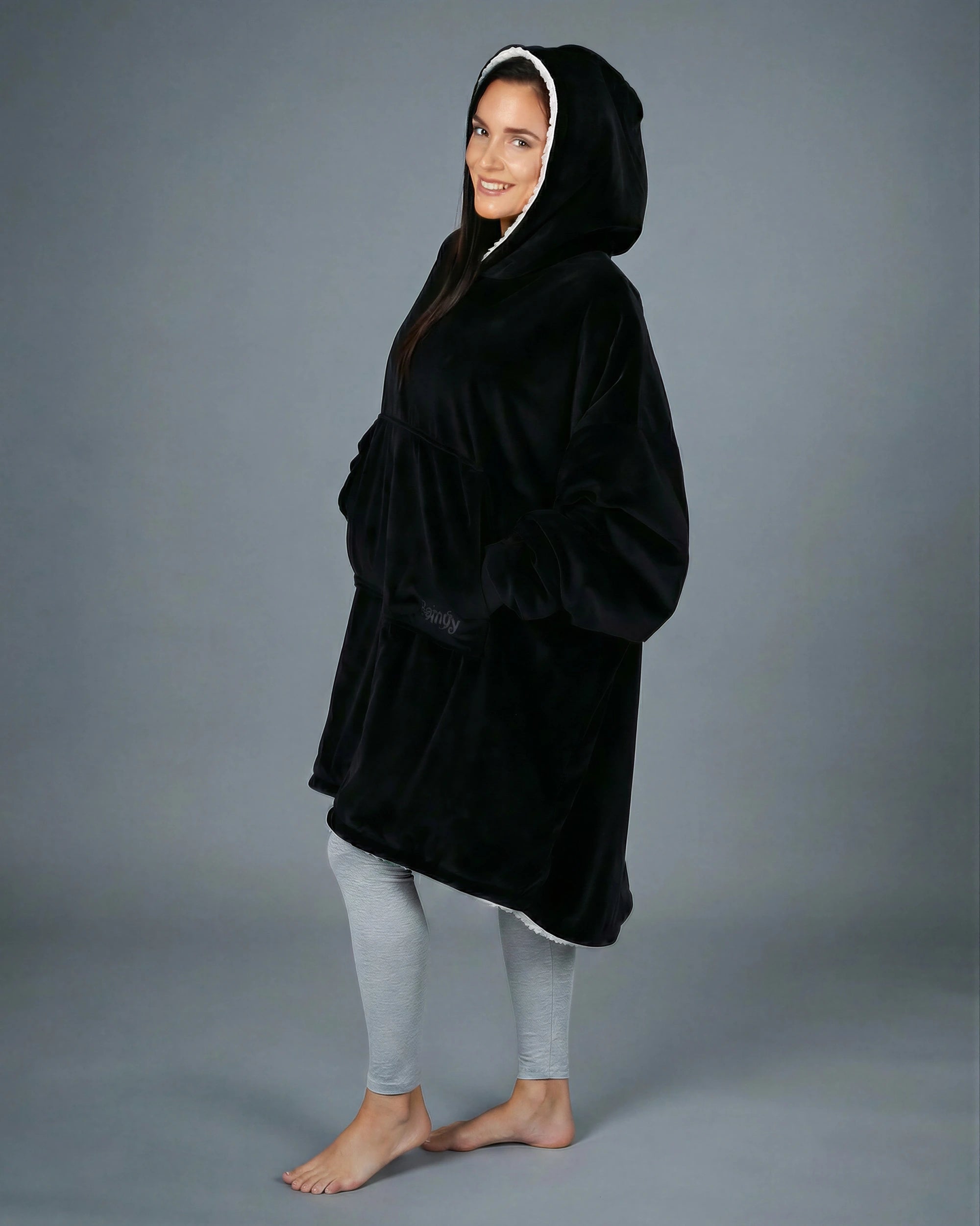 Side view of The Original wearable blanket in black showing oversized fit and hood design