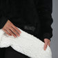 Close-up detail of The Original wearable blanket in black showing plush CloudSherpa™ lining and Velveluxe™ exterior