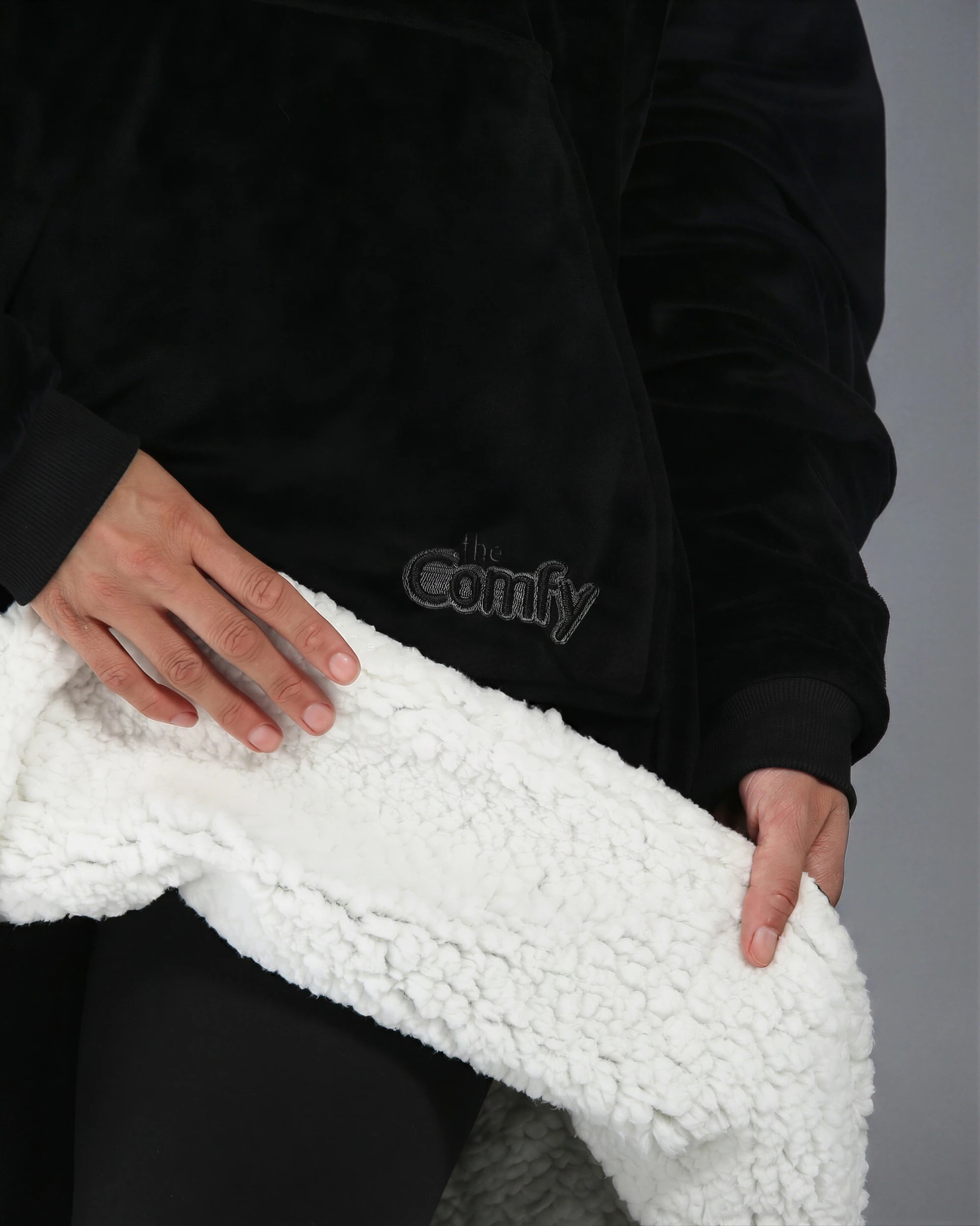 Close-up detail of The Original wearable blanket in black showing plush CloudSherpa™ lining and Velveluxe™ exterior
